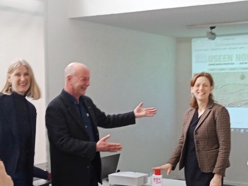 Kulturministerin Karin Prien betätig einen roten Startbutton mit der Aufschrift BBK. BBK-Vorstandsvorsitzender Anders Petersen hebt feierlich auf die Ministerin deutend die Arme. digiCULT Geschäftsführein Frauke Rehder lächelt ebenfalls begeistert.
